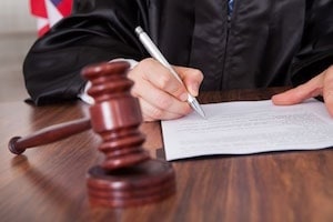 Gavel and a Man Signing a Document